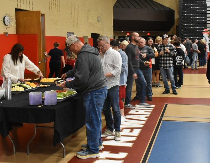 A group of people standing around a table with the word newark on the floor