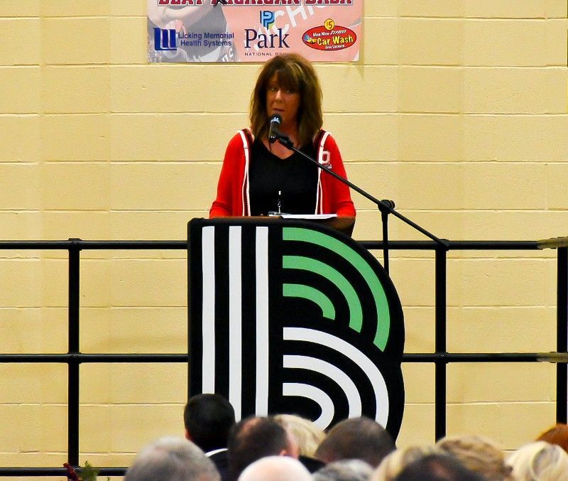 A woman stands at a podium with a sign that says park on it