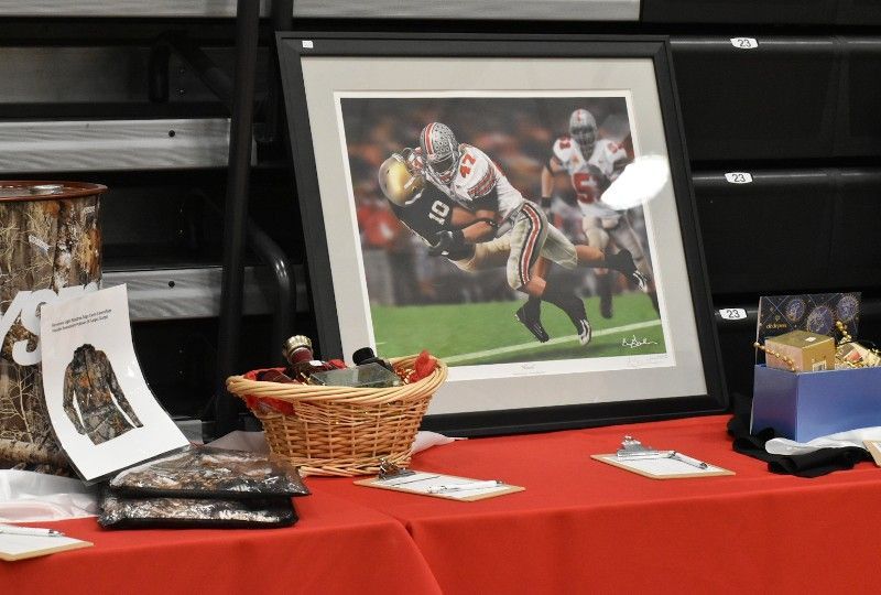A framed picture of a football game is on a table.