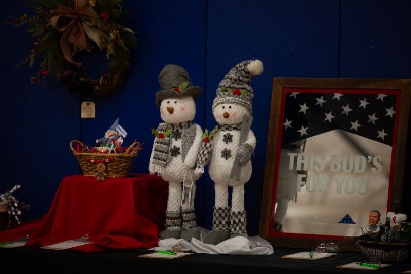 Two stuffed snowmen are standing next to each other on a table.