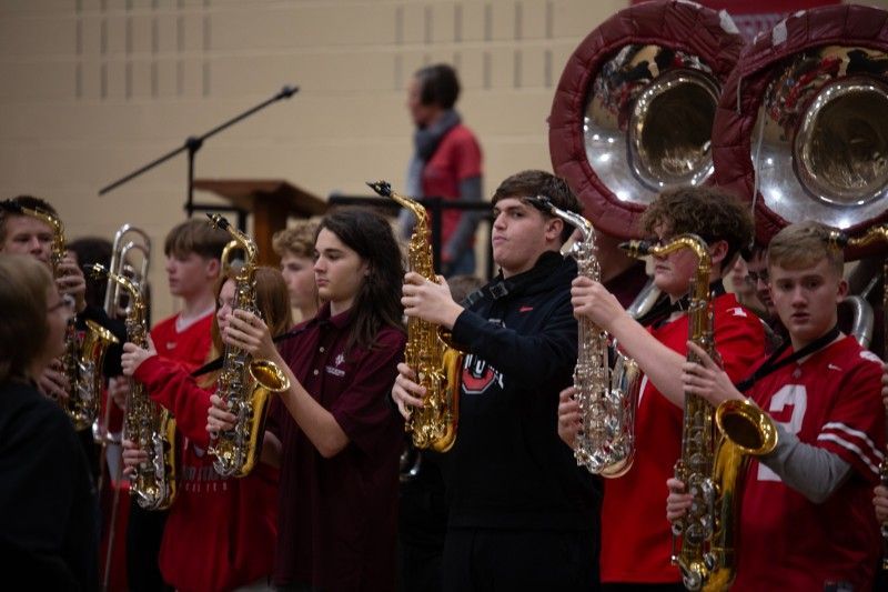A group of young people are playing saxophones in a band.