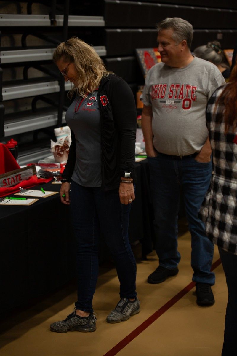 A group of people are standing around a table in a stadium.