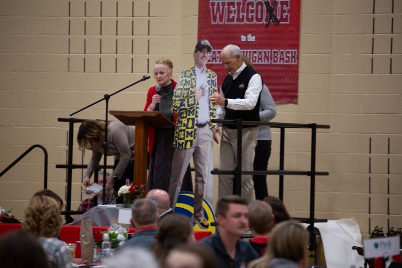 A group of people standing in front of a podium with a welcome sign in the background