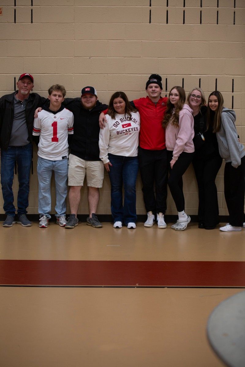 A group of people are posing for a picture in a gym.