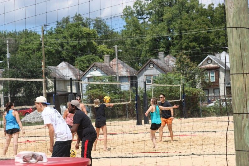 A group of people are playing volleyball on a sandy beach.