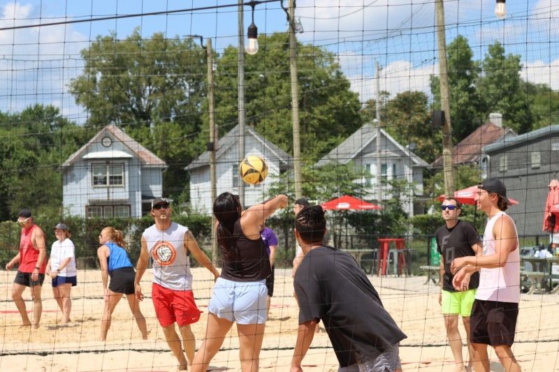 A group of people are playing volleyball on a beach.
