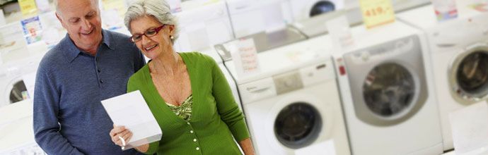 senior citizens standing around appliances