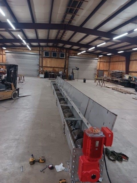 A large warehouse with a conveyor belt and a forklift