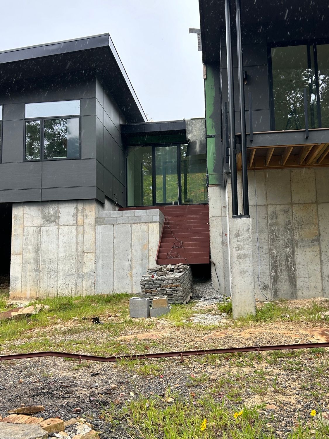 A house is being built on a hill with a lot of windows and stairs