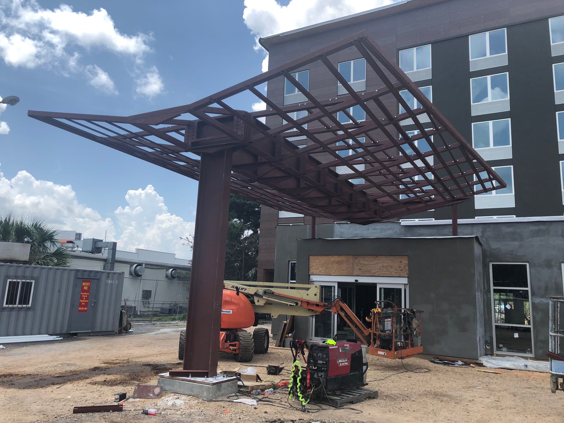 A large metal structure is being built in front of a building