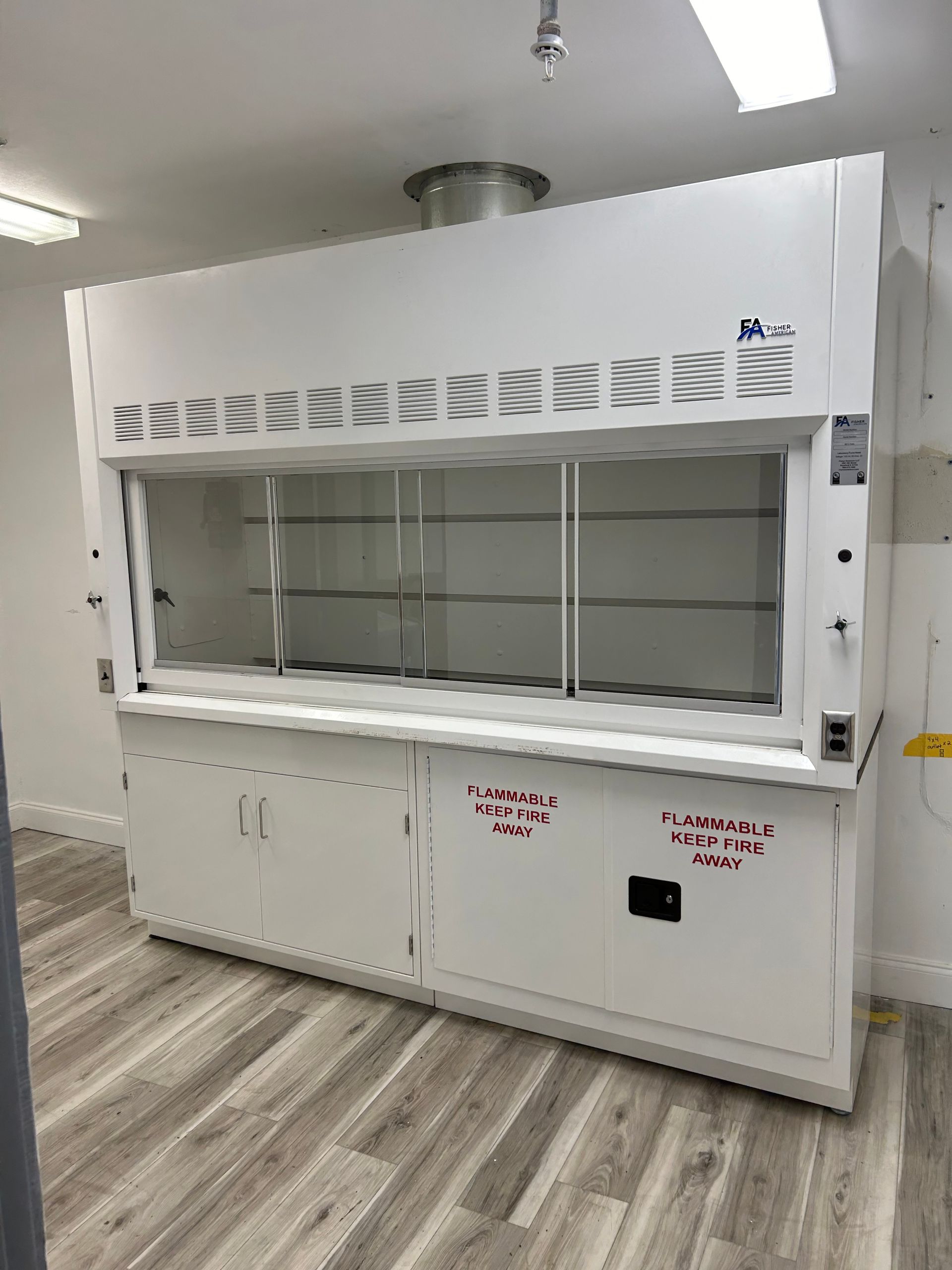 A large white cabinet in a room with a wooden floor