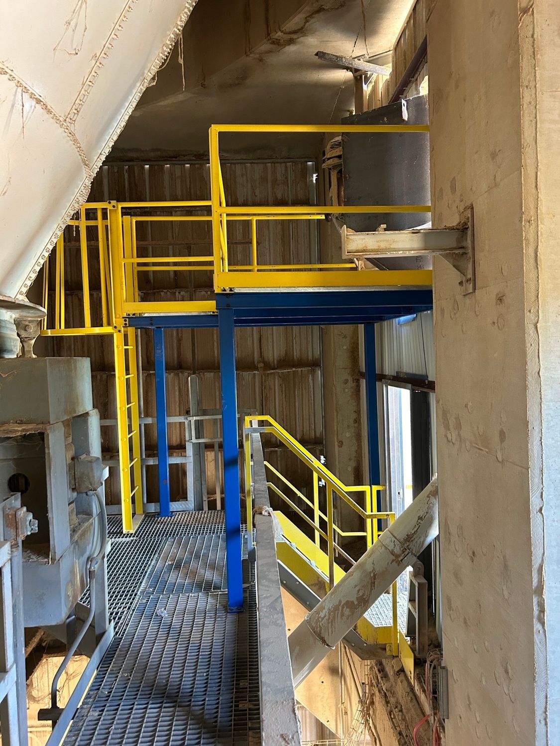 A factory with a yellow railing and stairs