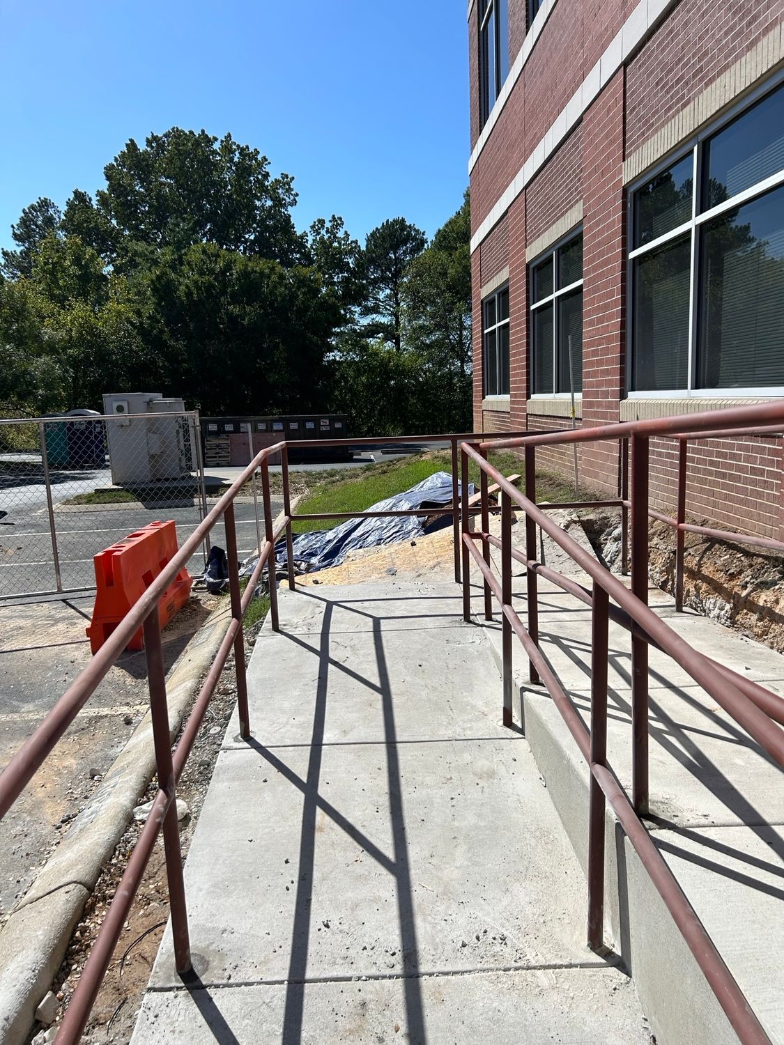 A ramp with a railing leading to a brick building