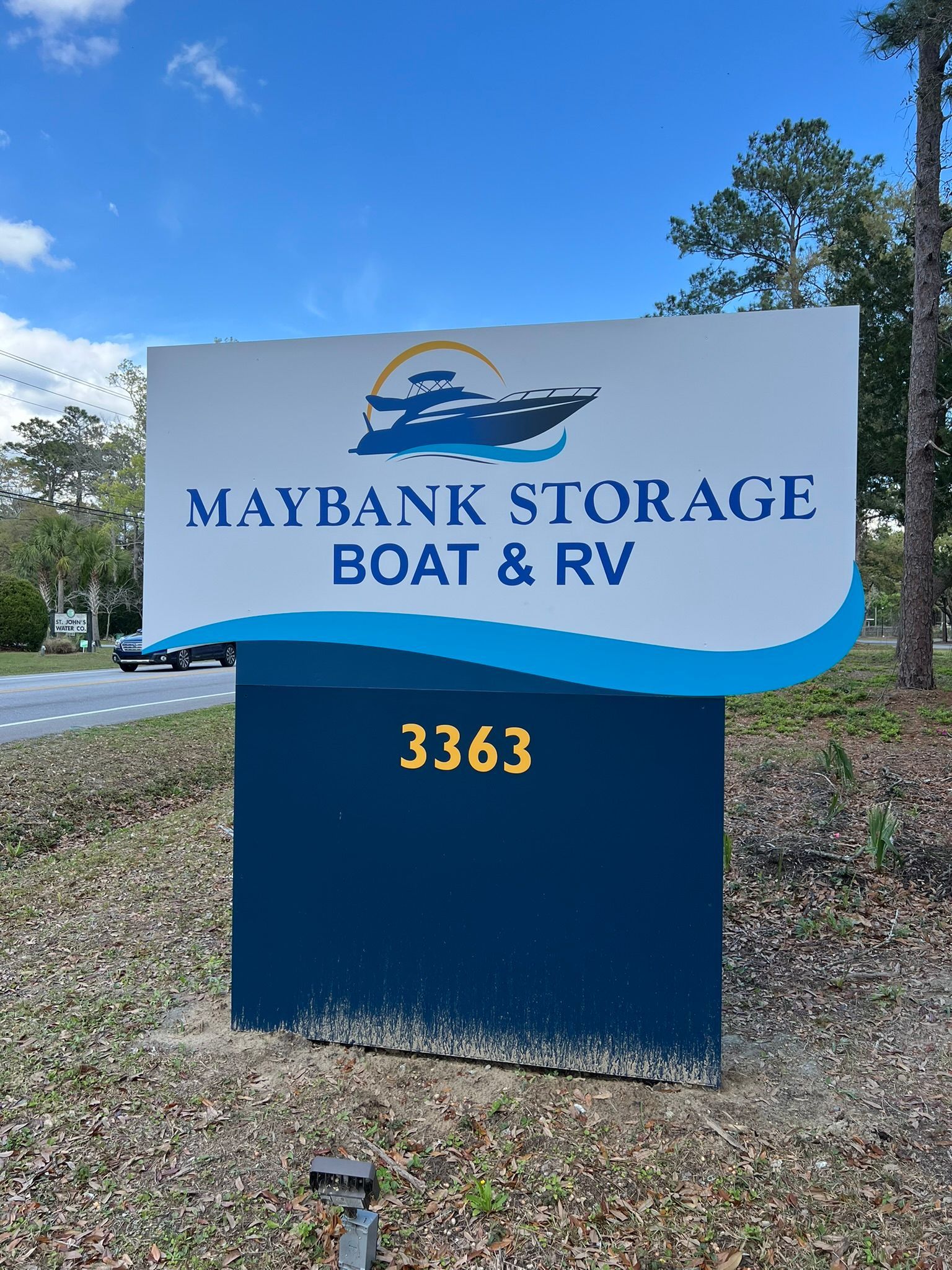 Sign for Maybank Storage Boat & RV with address 3363. White and blue with boat graphic, under a blue sky.