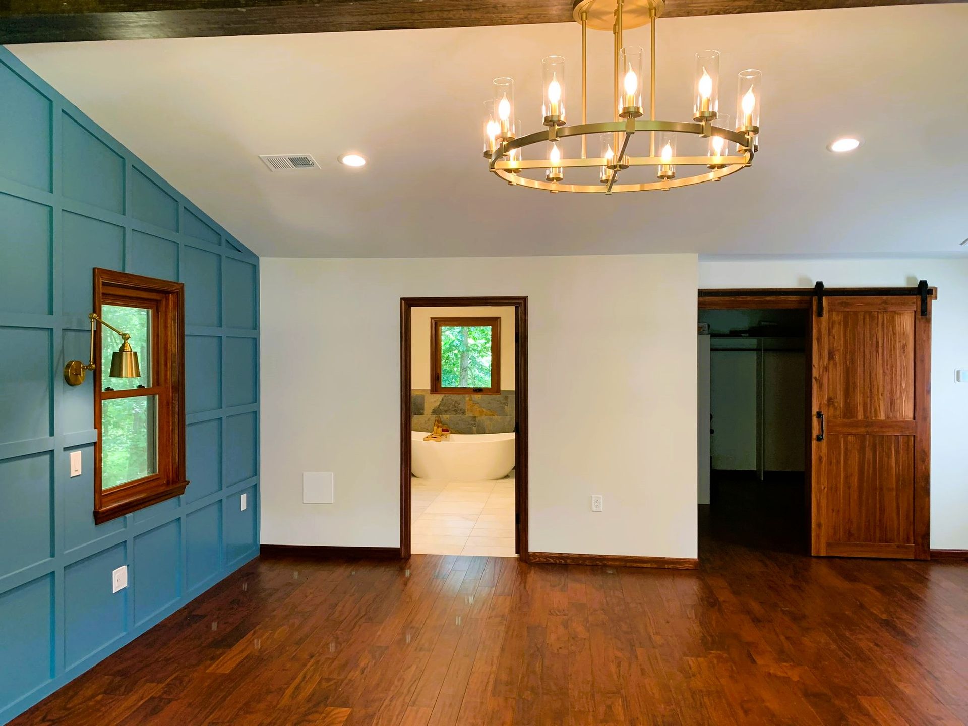 There is a chandelier hanging from the ceiling in the middle of the room.