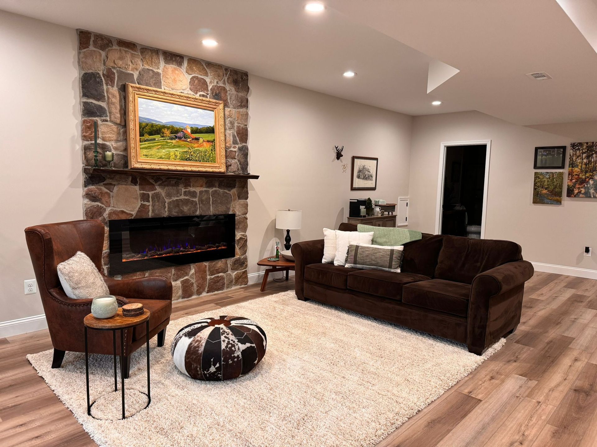 A living room with a couch, chair, and fireplace.