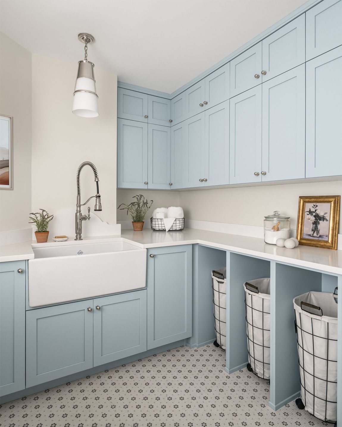 A laundry room with blue cabinets and a sink