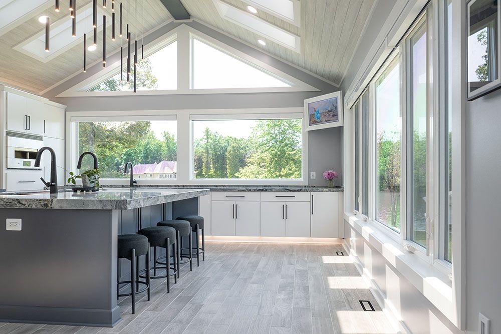 A kitchen with a vaulted ceiling and lots of windows