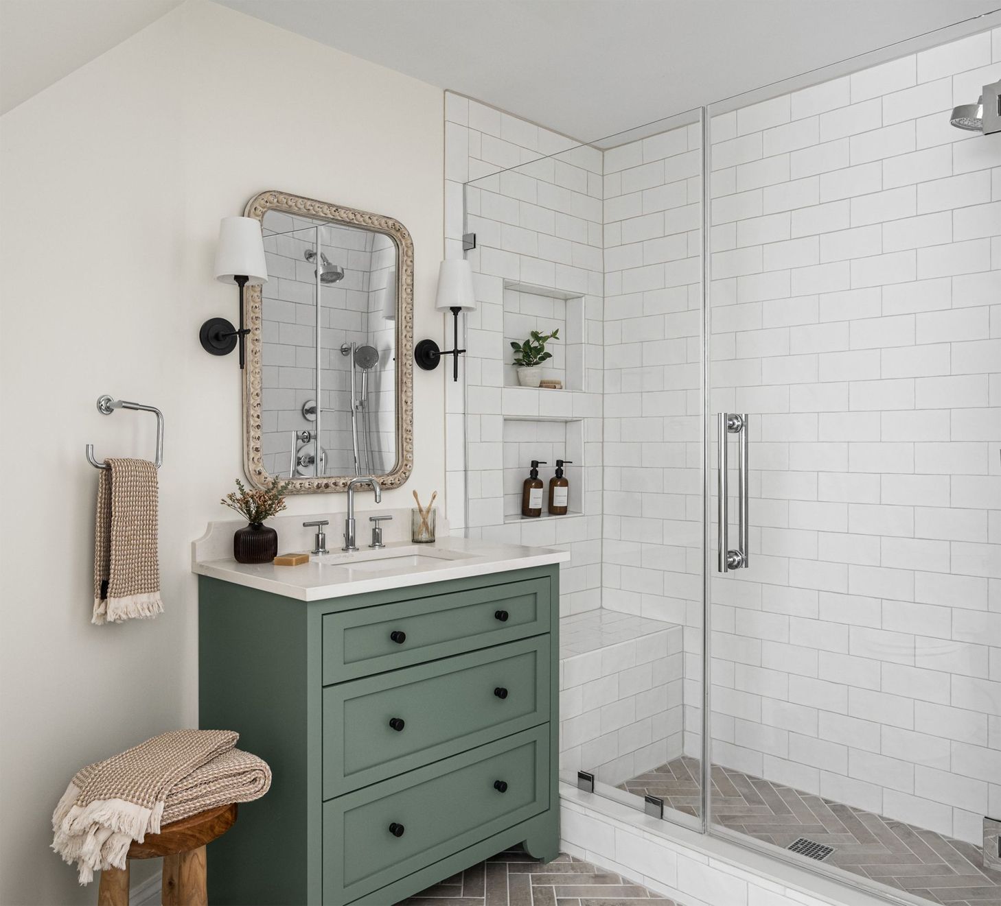 A bathroom with a green dresser, sink, mirror and shower.