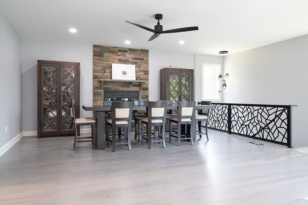 A dining room with a table and chairs and a ceiling fan