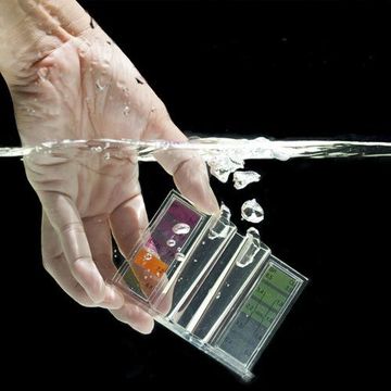 A person is holding a device in their hand in water