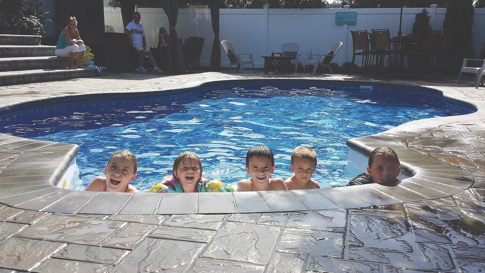 A group of children are swimming in a swimming pool