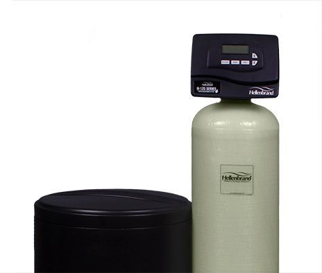 A water softener is sitting next to a black container on a white background.