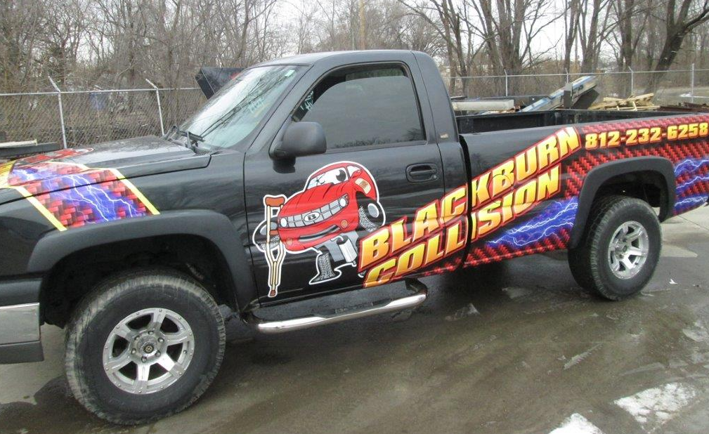 Black pickup truck with Blackburn Collision logo. Red and yellow graphics on black paint. Phone number on the side.