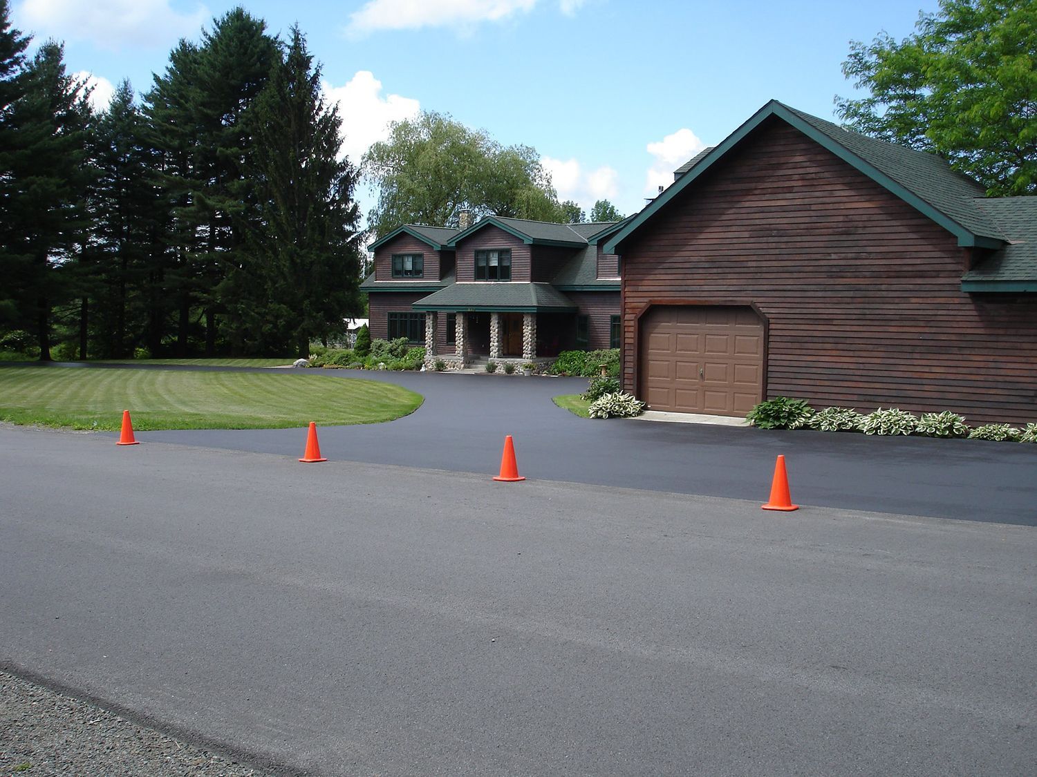 A driveway with orange cones in front of a house