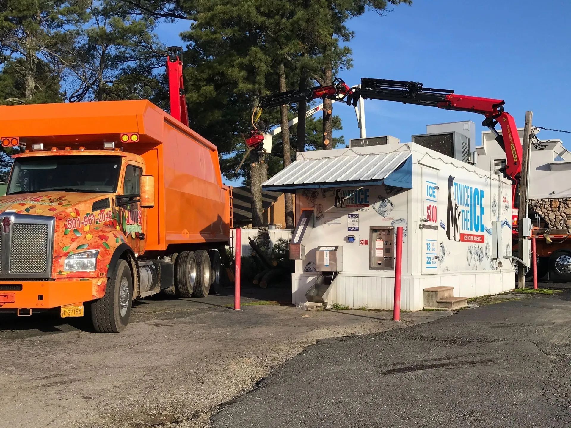 A truck with a crane attached to it is parked in front of a building.