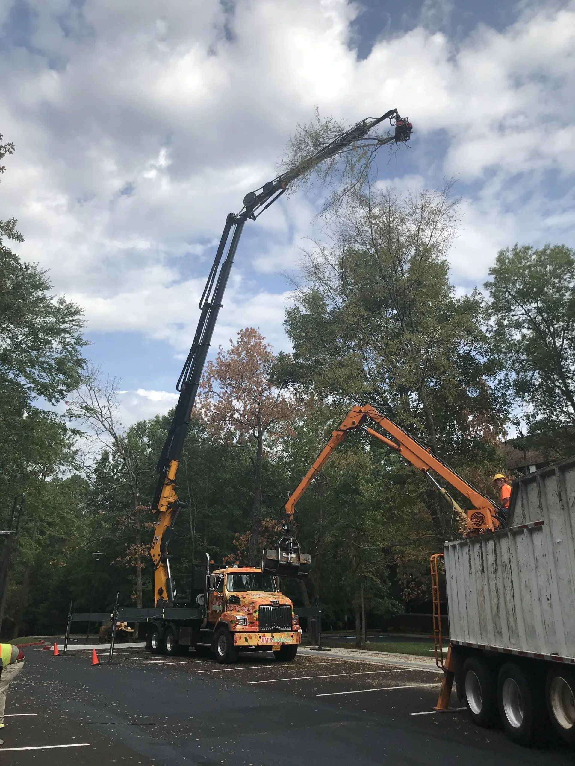 A truck with a crane attached to it is parked in a parking lot