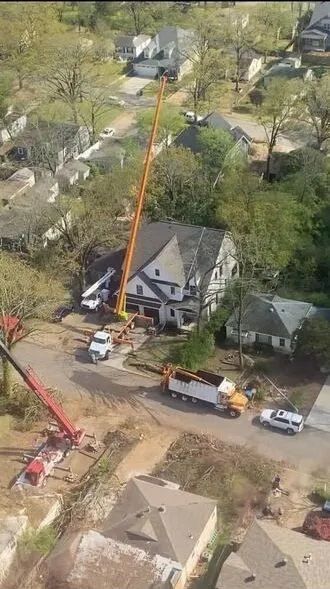 An aerial view of a residential area with a crane and a truck.