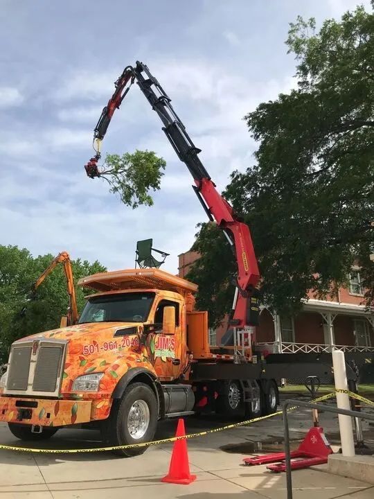 An orange truck with a crane attached to it