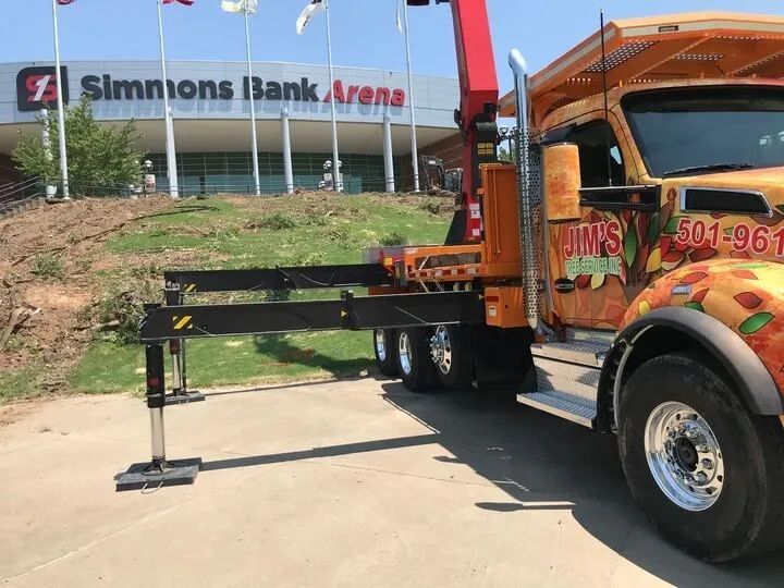 A tow truck is parked in front of a simmons bank arena.