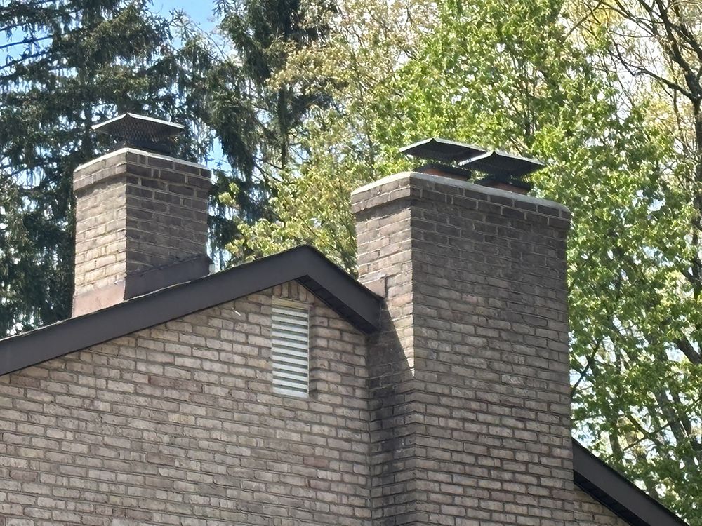 A brick house with two chimneys on top of it