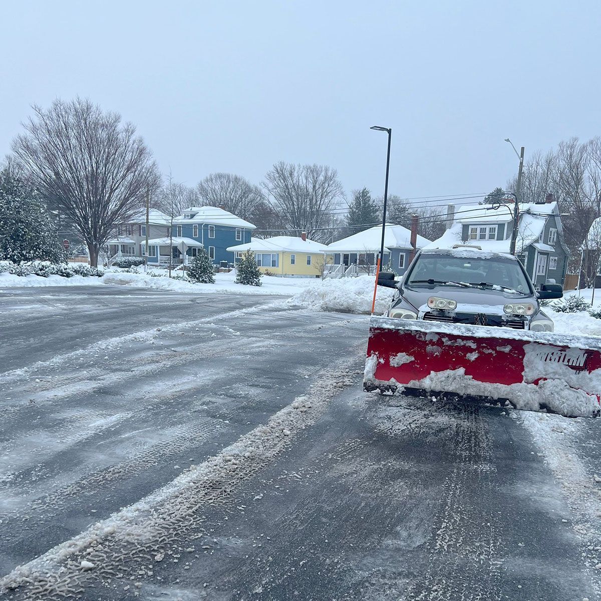 A snow plow is clearing snow from the road