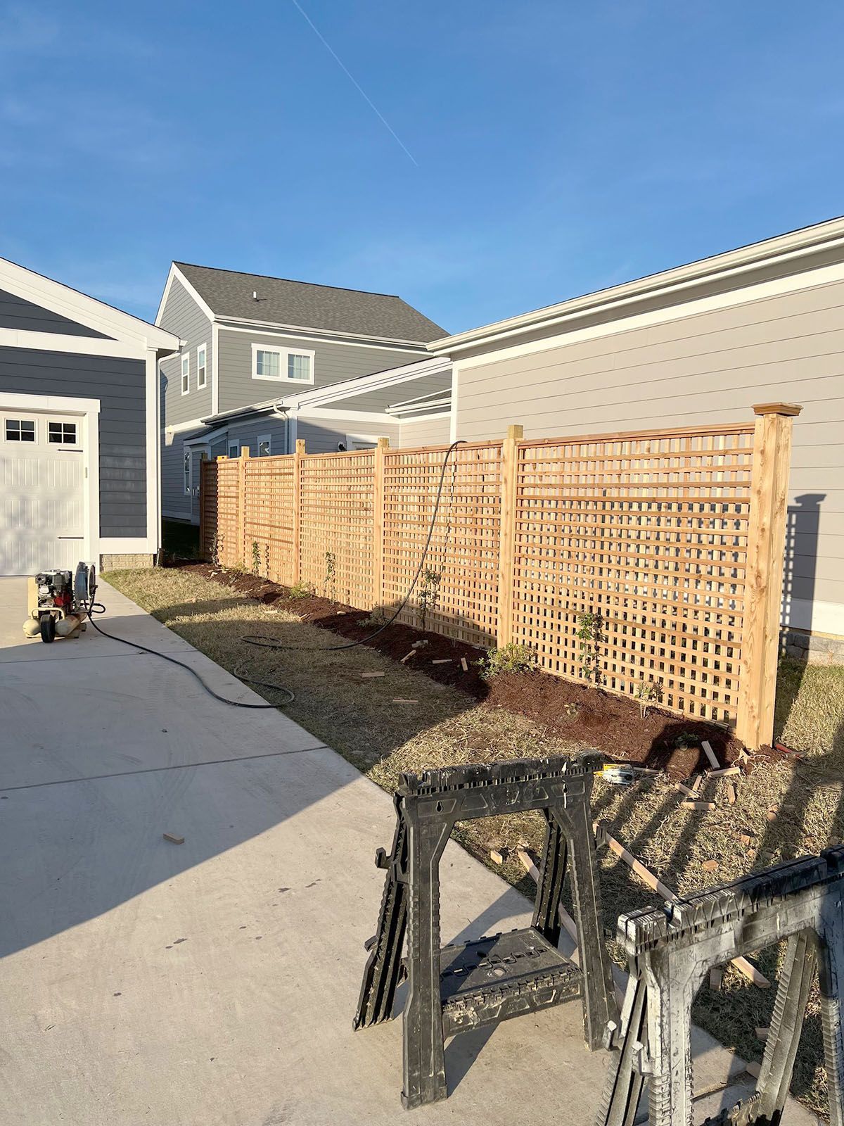 A wooden fence is being built in front of a house