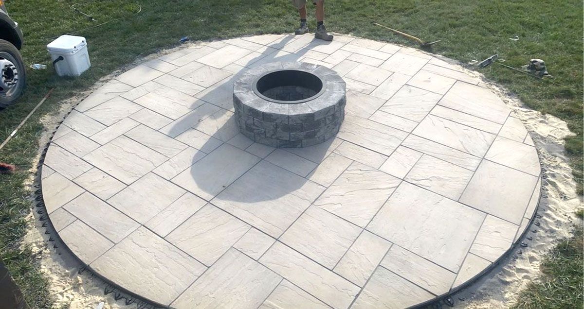 A fire pit is sitting in the middle of a circular patio