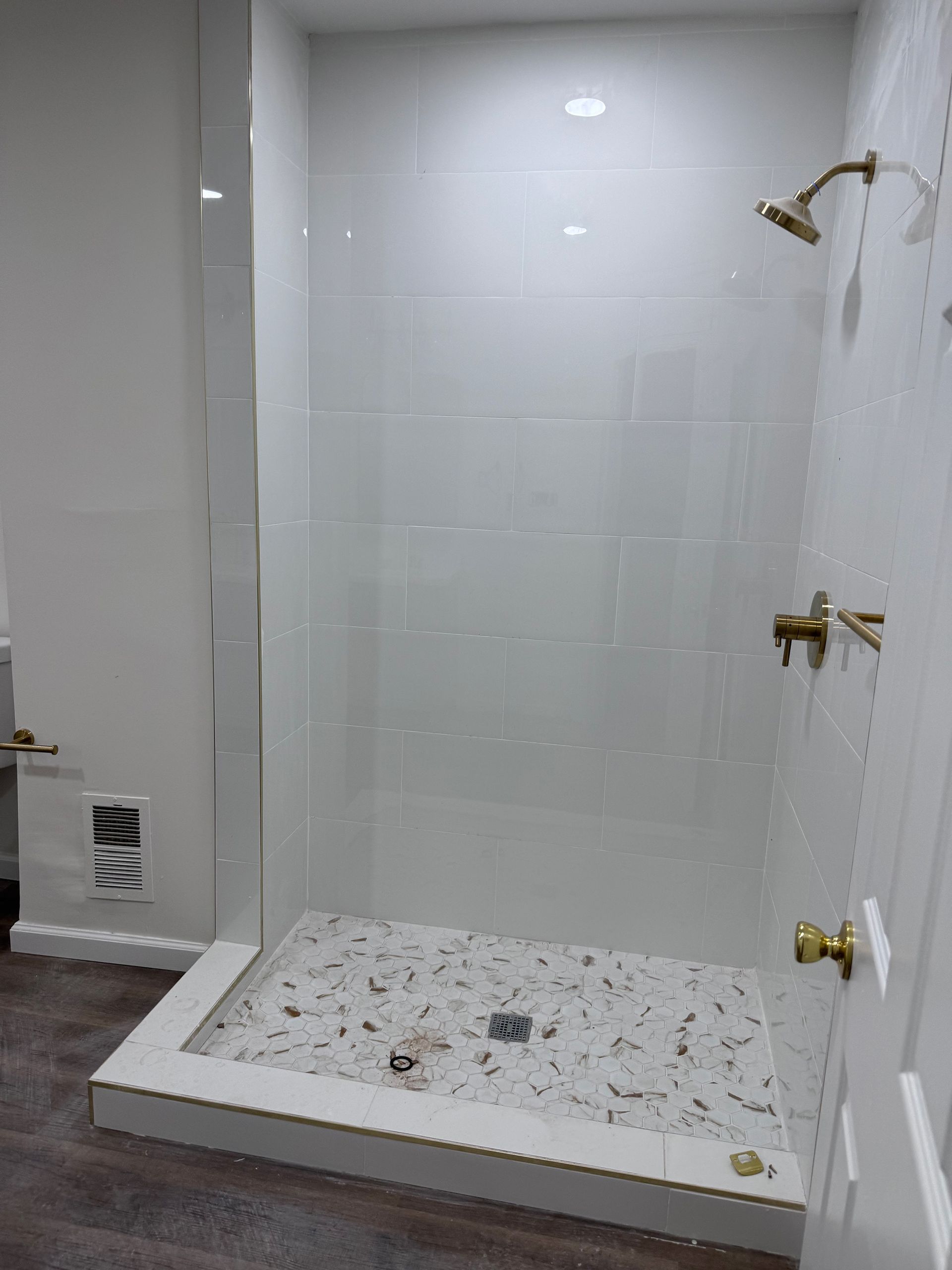 A bathroom with a walk in shower and a sink.