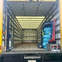 Interior of an empty moving truck with blue moving blankets and supplies, ready for loading.