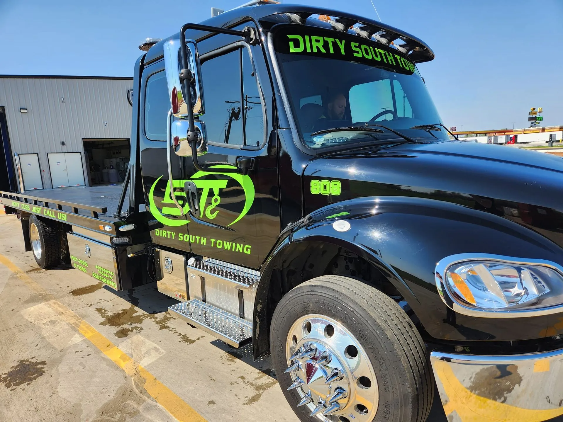 Black tow truck with green logo and "Dirty South Towing" text.