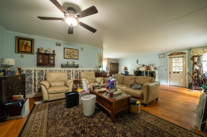 A living room filled with furniture and a ceiling fan.