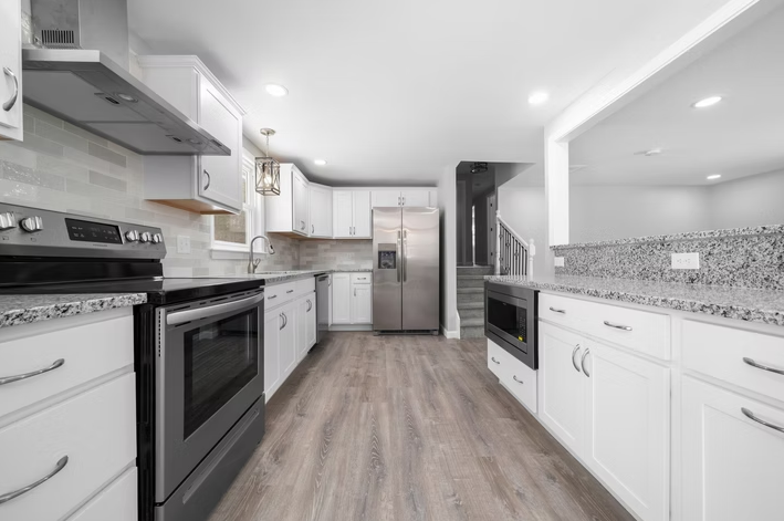 A kitchen with white cabinets and stainless steel appliances.