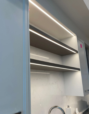 Modern kitchen with open shelves, under-cabinet lighting, and a white marble backsplash