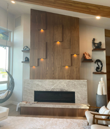 Modern living room with a wood accent wall, built-in fireplace, and decorative shelves with sculptures.