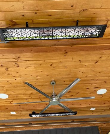 Wooden ceiling with a large ceiling fan and a long skylight window above it