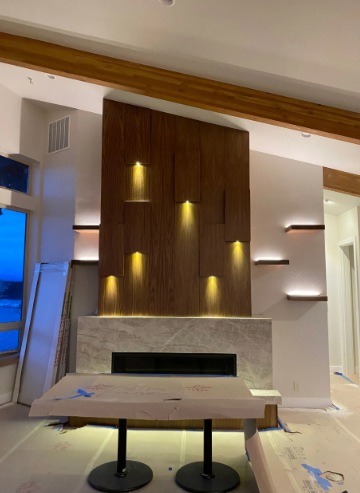 Modern living room with a wood fireplace wall, built-in lights, and a TV console in the foreground