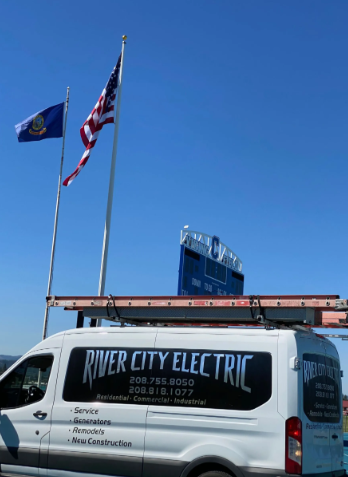White River City Electric service van parked outdoors under blue sky with utility flags and a brick building behind