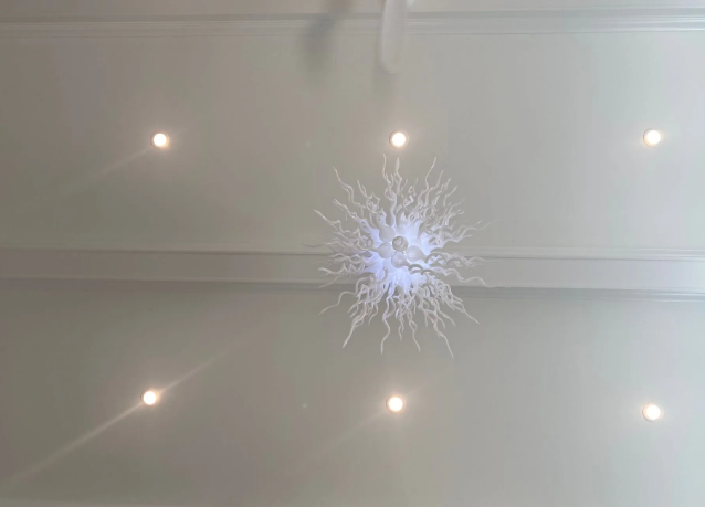 White ceiling with recessed lights and a central starburst crack or decorative fixture.