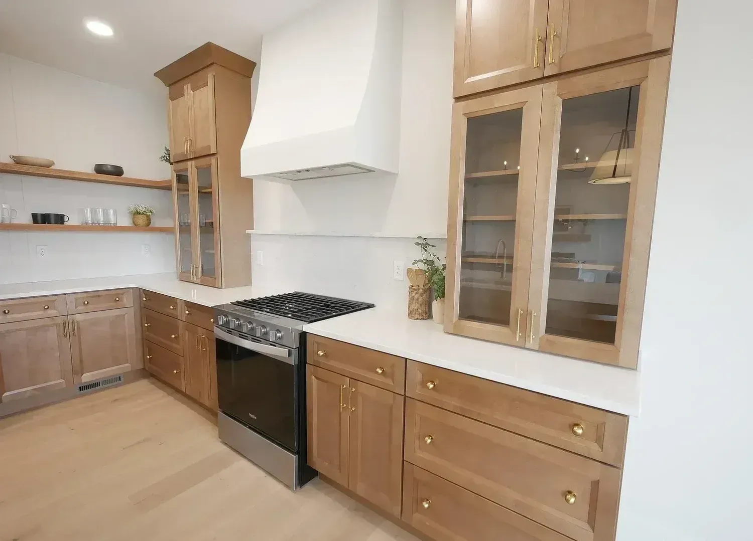 Kitchen with light wood cabinets, white countertops, and stainless steel appliances.